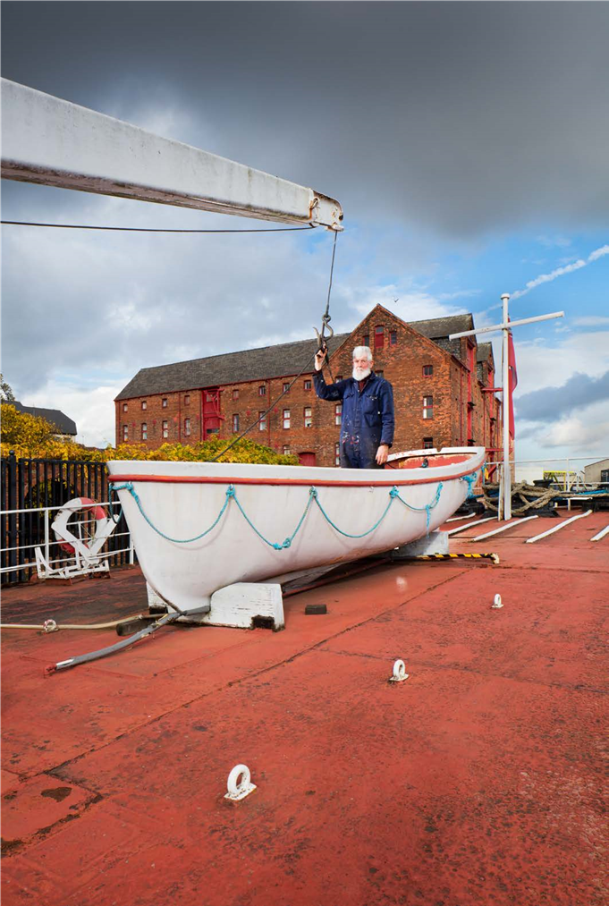 Photograph of fisherman Colin Silvert Screeton with a lifeboat on the deck of the trawler Arctic Corsair, launched in 1960. Hull, East Yorkshire