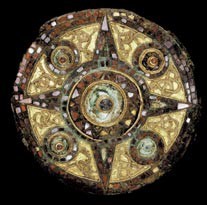 Circular metal and inlaid brooch with a four point star in the centre and four circles.
