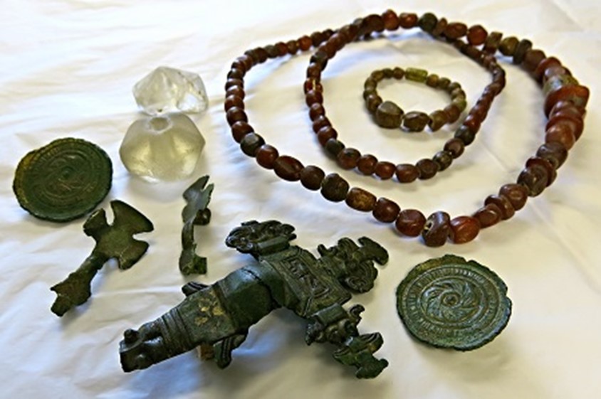 Photograph of Early Medieval/Anglo Saxon artefacts discovered in Upton Snodsbury in the late 19th century. Artefacts include a necklace of amber beads, a glass ball and brooches of both cruciform and saucer shape.
